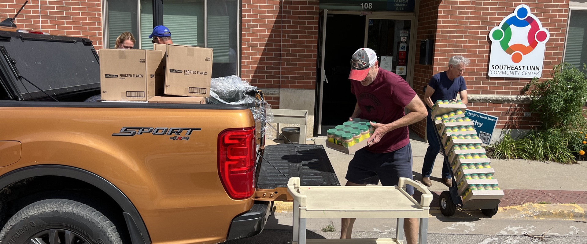 Volunteers unloading bulk food items from personal truck and taking items into Southeast Linn Community Center