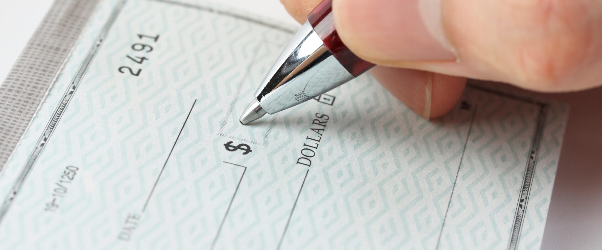 Close-up of pen writing a check